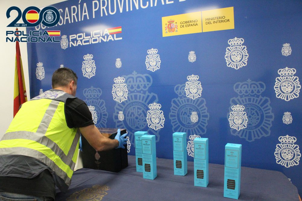 Detenidos por robarle siete botellas de whisky de lujo a un familiar: una estaba valorada en 80 mil euros - policia whisky lujo Imagen de un agente de la Policía Nacional con las botellas recuperadas.